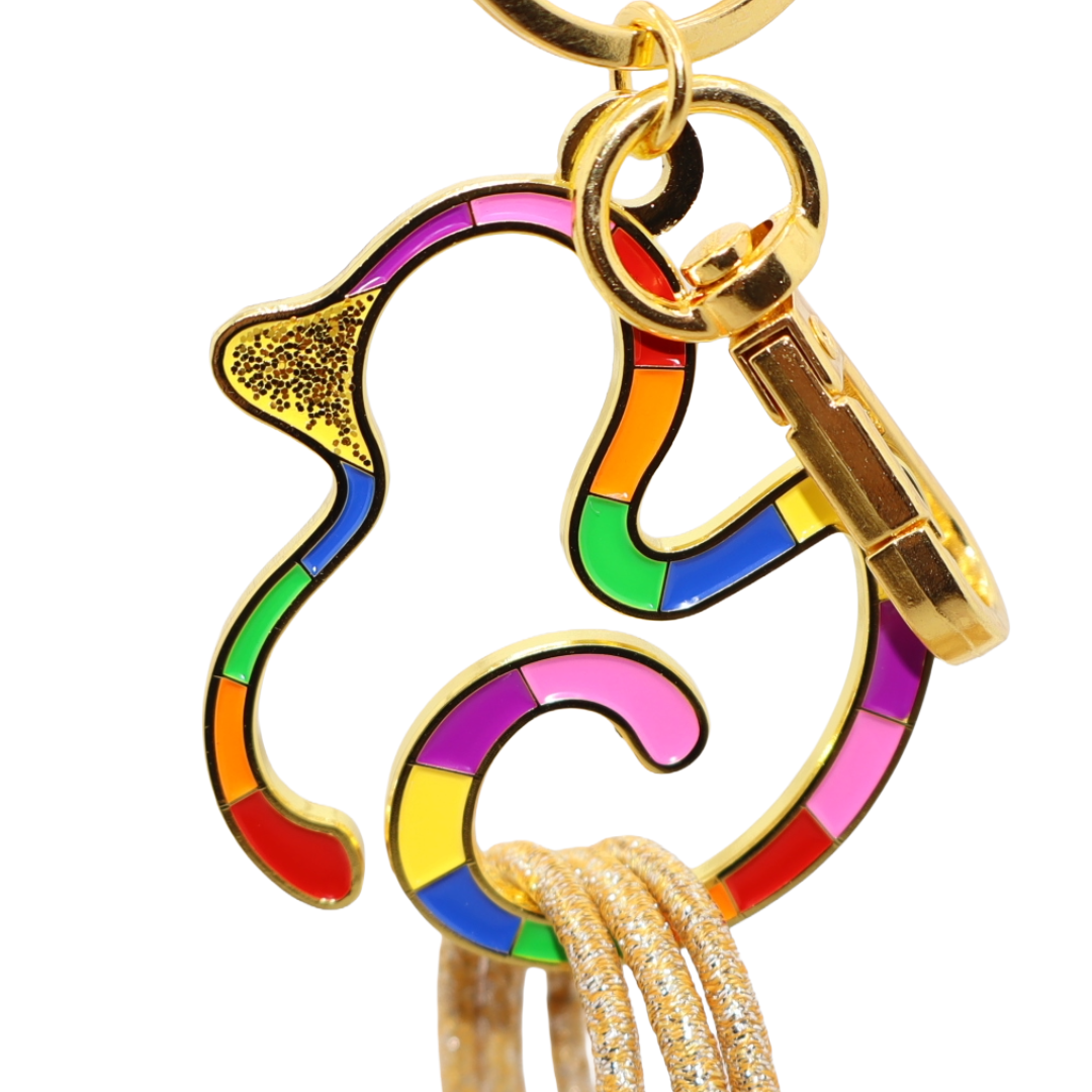 Colorful duck keychain with gold accents on a white background